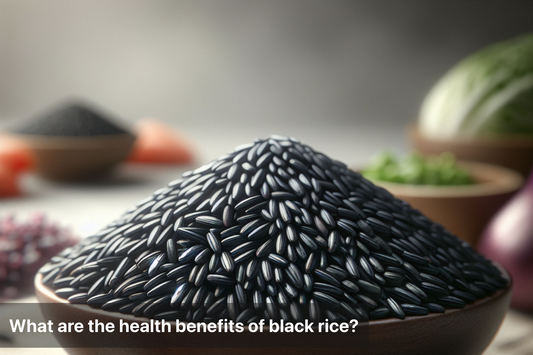 A mound of black rice with fresh vegetables in the background